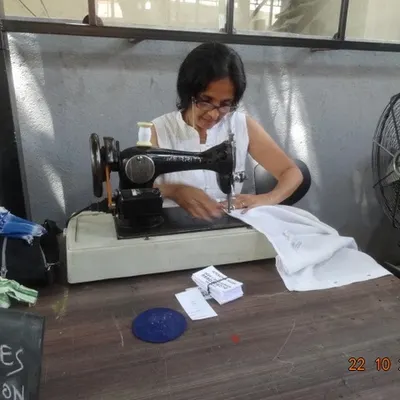 A participant uses a classic sewing machine at our workshop. We embrace both traditional and modern techniques to mend and maintain textiles.
