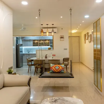 A full tour of a stunning 3BHK home where every room is crafted for comfort and style. This view shows the open-plan living and dining area, complete with a statement swing and a custom crockery unit, designed for a family of four.