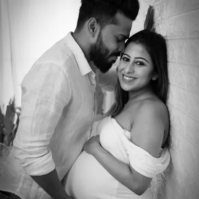 A classic and intimate black and white couple's portrait. The soft lighting and close framing emphasize the tender connection between the partners.