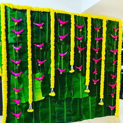 A completely natural and traditional backdrop made from fresh banana leaves, adorned with vertical garlands of yellow marigolds. This eco-friendly design is deeply rooted in South Indian wedding traditions.