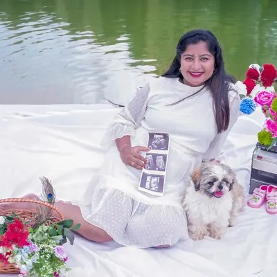 A sweet outdoor picnic setup by the water. Including the ultrasound scan pictures and the family pet makes this pregnancy announcement so personal.