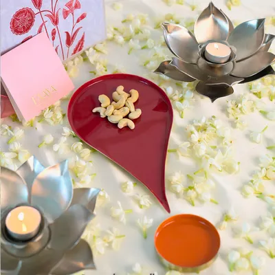 Some shapes tell a story. This one begins with a dot. Our Bindu plate, shaped like the symbol of beginnings, is shown here holding cashews, next to lotus-shaped diyas. It’s a piece designed to bring meaning to your festive moments.