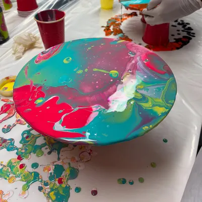 A finished fluid art piece on a round canvas, created during a Holi-themed workshop. The way the colors blend and create unique patterns is always mesmerizing.