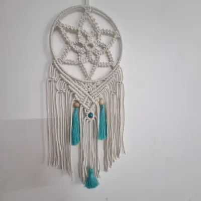 This full view of my macrame dreamcatcher shows the intricate star pattern and delicate tassels. It's a beautiful piece to hang above a bed or in a living room to catch good dreams and add a peaceful vibe.