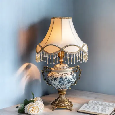 This Victorian lamp is a true classic, featuring a blue-and-white floral porcelain base and a scalloped shade with crystal bead fringe. It’s a statement piece that brings a sense of history and elegance to a side table or desk.