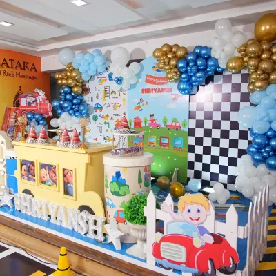 A closer look at the Cocomelon birthday stage, showing the checkered racing flag backdrop panel and a cute car cutout, adding more detail to the transportation theme.