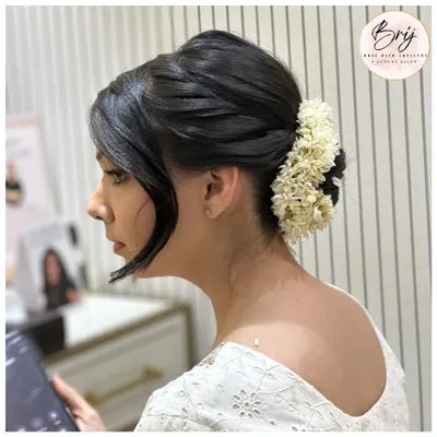 Elegance in a twist. This quick, sleek bun adorned with fresh flowers is classy, fierce, and forever sophisticated.