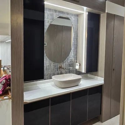 This wash basin area combines style and function. I used a mix of dark wood, a textured tile backsplash, and integrated lighting to create a sophisticated and practical vanity space.