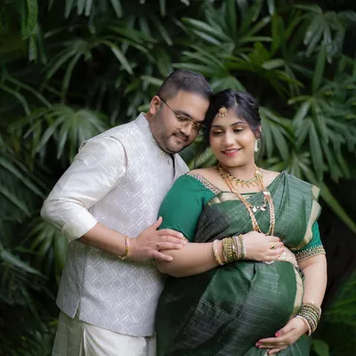 An intimate portrait from an outdoor maternity session. The lush green background provides a natural and peaceful setting for capturing the connection between the parents-to-be.