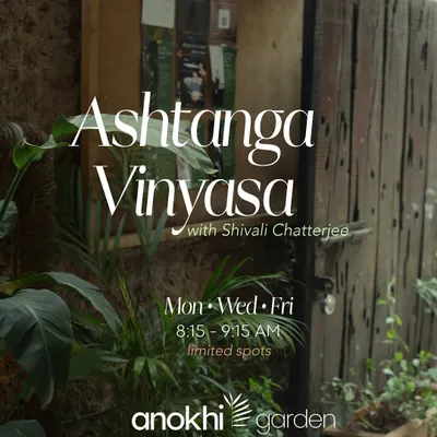 The rustic wooden entrance to Anokhi Garden, surrounded by lush greenery. This image captures the essence of our space as a hidden oasis in the heart of Khar West.