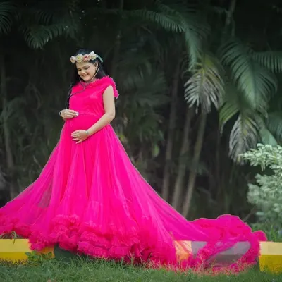 Make a bold statement with this vibrant fuchsia gown. Its long, ruffled train adds drama and movement, perfect for creating stunning portraits in any outdoor setting.