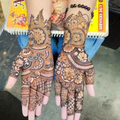 A rich and dense bridal mehndi design featuring bold paisley and floral patterns. The dark stain highlights the detailed work, perfect for wedding photography.