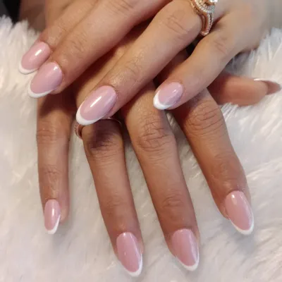 The epitome of elegance: a perfect, classic French manicure on medium-length oval nails. This timeless look is always in style.
