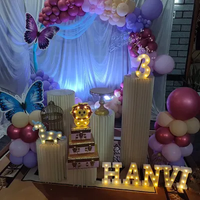 This butterfly-themed party for a 3rd birthday used a soft purple and pink color palette. The setup includes a circular balloon arch, marquee letters for the name, and delicate butterfly accents.