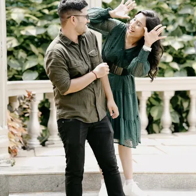 A hilarious, candid moment of a couple being goofy and playful in a garden gazebo, showing their fun-loving side.