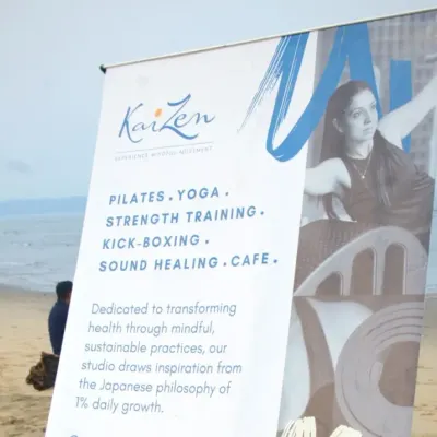 Our Kaizen Goa banner at a beach yoga workshop. My studio is dedicated to transforming health through mindful, sustainable practices. We offer Pilates, Yoga, Strength Training, and more, all inspired by the philosophy of one percent daily growth.