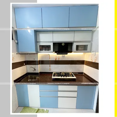 A compact and efficient modular kitchen designed for a 1BHK apartment in Dronagiri. The blue and white acrylic finish gives it a fresh and modern look, while the layout maximizes storage and workspace.