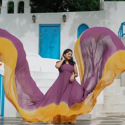 This dual-tone purple and yellow flying gown creates a stunning effect against a bright, Santorini-themed backdrop. The lightweight fabric allows for maximum air time, resulting in a beautiful, flowing shape.