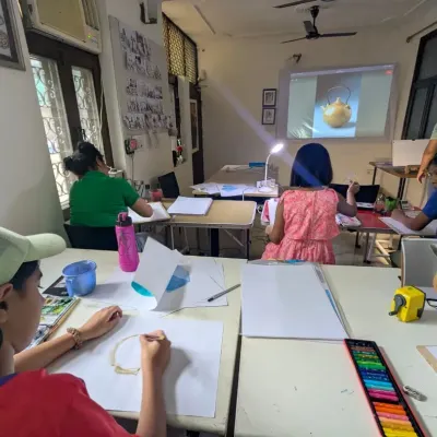 A snapshot of a typical class in our studio. Students are focused on their still life paintings, using a mix of digital projections and real objects for reference.
