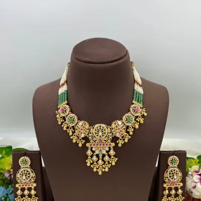 An antique-style necklace set with intricate detailing and multi-color stones, shown from different angles.