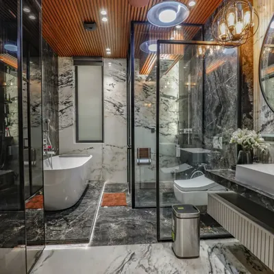 A luxury bathroom in Vikaspuri where I used dramatic black and white marble on both the floors and walls. The space features a freestanding tub, a glass-enclosed shower, and a wooden ceiling for warmth.