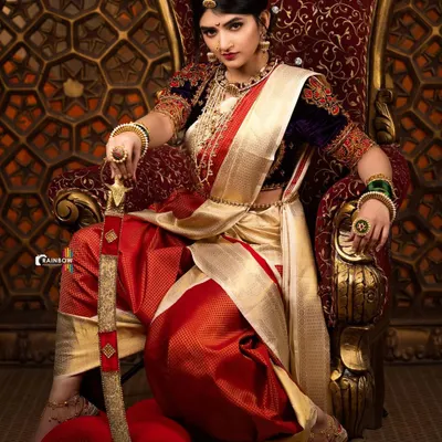 A powerful portrait of actress Sreeleela, embodying a warrior queen. This shot focuses on her commanding gaze and the rich details of her attire, set against an ornate, traditional backdrop.