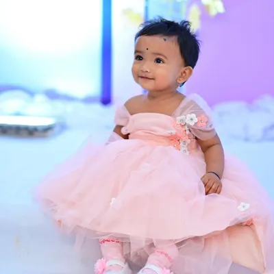 An adorable little client in her custom-designed pink party dress. This dress features a tulle skirt and 3D floral embellishments on the shoulder.