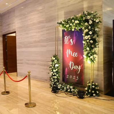 This custom-branded photo booth for "It's Mee Day 2023" provided a fun and interactive element for guests. The floral frame and professional lighting created a perfect spot for memorable photos at the corporate evening event.