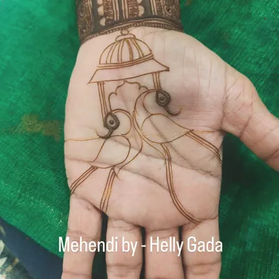 The beginning of a beautiful peacock design. This shows the clean, simple outline of two peacocks under a traditional 'doli' or palanquin, a classic motif in wedding mehndi.