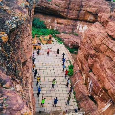 A unique perspective from above, showing our group warming up in a historic courtyard nestled between the magnificent cliffs of Badami before a day of climbing.