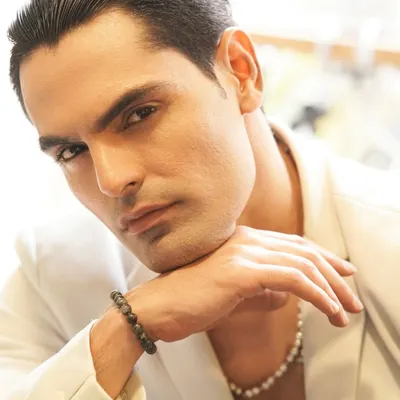 For this men's editorial, the goal was a sharp, high-fashion look. I used a clean base to even out the skin tone and styled the hair with a sleek, wet finish to complement the modern, edgy styling.