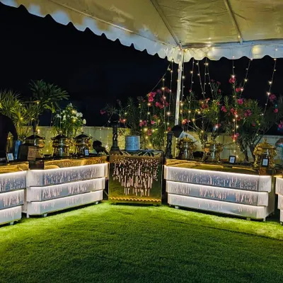 My premium banquet hall in Sahakarnagar, set up for an evening event. The rooftop garden space with illuminated counters creates a beautiful ambiance for any occasion.