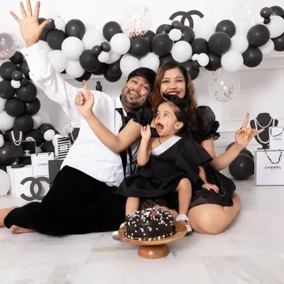 Celebrations should be full of life and personality. This family is having a blast during a Chanel themed cake smash session, complete with a custom balloon arch and designer props provided by our studio.