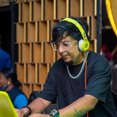 Focused on the mix at Badmaash in Koramangala. I am fine-tuning the tracks on my laptop, ensuring a seamless flow of music for the crowd.