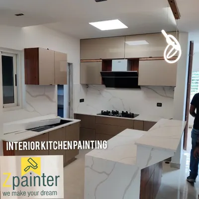 A stunning modern kitchen achieved with professionally painted cabinets. The smooth, beige laminate finish is paired with wood accents for a sophisticated, two-tone effect.