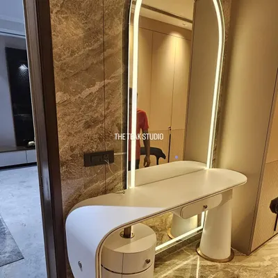 I love creating statement pieces like this custom dresser. It features a minimalist curved design, a built-in arched mirror with ambient LED lighting, and unique cylindrical drawers with brass details for a touch of glamour.