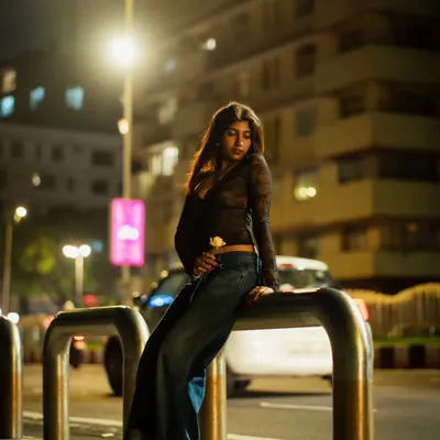 A full-body portrait from a night shoot in Mumbai. I used a street barrier as a prop to create a relaxed, editorial pose against the backdrop of city lights.