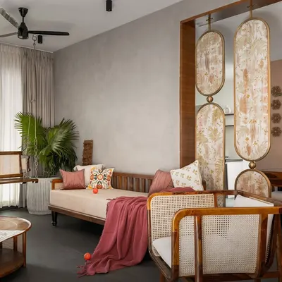 This living room from the 'Ittige' project is a perfect example of our integrated approach. The space flows seamlessly, furnished with a mix of contemporary sofas, a traditional swing, and artful partitions that define areas without closing them off.