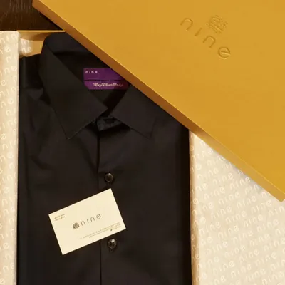 A classic black bespoke shirt, perfectly folded and presented in our signature yellow gift box. This is a timeless and practical gift for a valued business partner or employee.