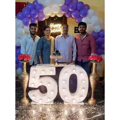 A family celebrating a 50th birthday with our marquee number setup. The large, lit-up "50" provides the perfect centerpiece, framed by a purple and white balloon arch for a festive and memorable family photo.