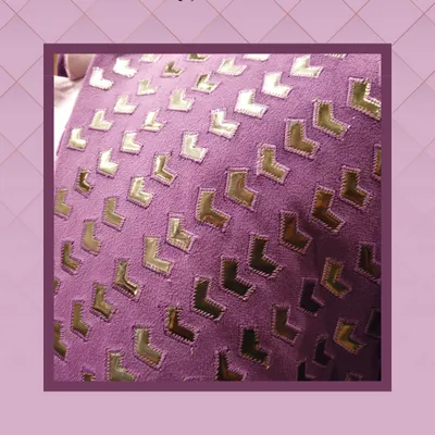 This image shows a close-up of one of the exclusive fabrics I offer for custom tailoring. The rich purple material features a modern, L-shaped geometric pattern in reflective gold, perfect for creating a standout jacket or kurta.