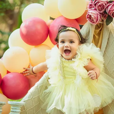 The pure joy of an outdoor celebration. This little girl's excitement is infectious in this beautiful park setting with a teepee and balloons.
