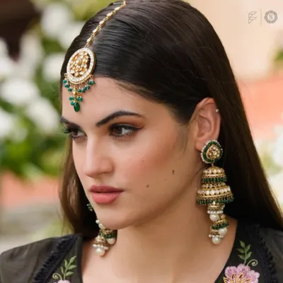 A close-up of our beautiful green beaded jhumkas and matching maang tikka. These accessories are perfect for adding a pop of color and traditional flair to any outfit.