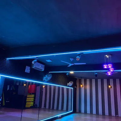 A view of our dance studio, featuring full-length mirrors framed with neon lights. This setup helps our dancers perfect their form and technique from every angle.