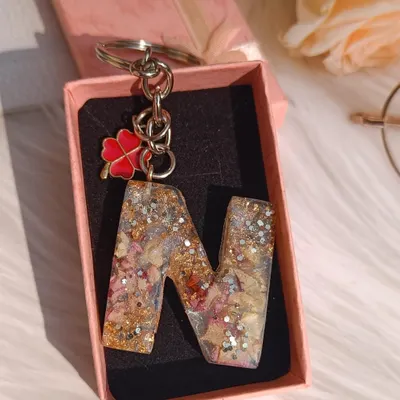 This 'N' alphabet keychain is filled with a customer's special flower petals, silver glitter, and gold flakes. I added a lucky four-leaf clover charm to finish the piece.