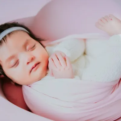 So tiny, so perfect, so loved. This newborn girl is sleeping peacefully in a heart-shaped bowl, a beautiful way to remember just how small she once was. This is a classic newborn pose.