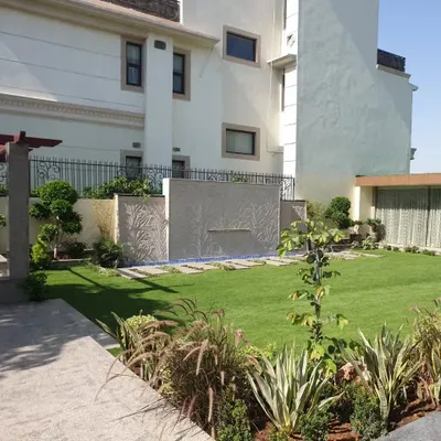 A complete mini-farm landscape with a lush lawn, a modern water feature, and carefully selected border plants to create a private retreat.