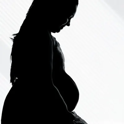 A classic silhouette portrait of a mother-to-be. This artistic style focuses on the beautiful curve of the baby bump, creating a timeless and emotional image.