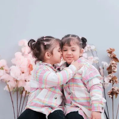 A sweet kiss between twin sisters during their boho-themed studio session. We love creating a playful space for kids to be themselves.