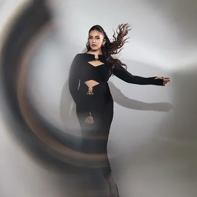 Huma Qureshi in a powerful black dress by Label Riya. The strategic cutouts and long sleeves create a silhouette that is both elegant and edgy, captured here with a dynamic motion blur.
